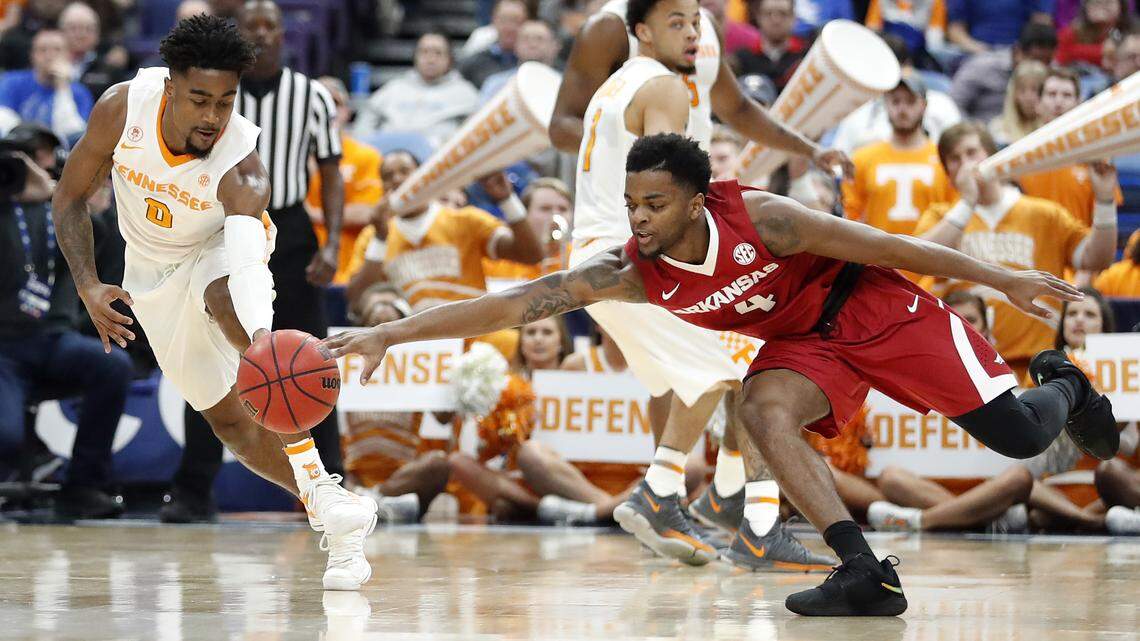 Tennessee’s Jordan Bone, left, and Arkansas’ Daryl Macon dive after a loose ball during the first half of an NCAA college basketball game in the semifinals of the Southeastern Conference tournament Saturday, March 10, 2018, in St. Louis.