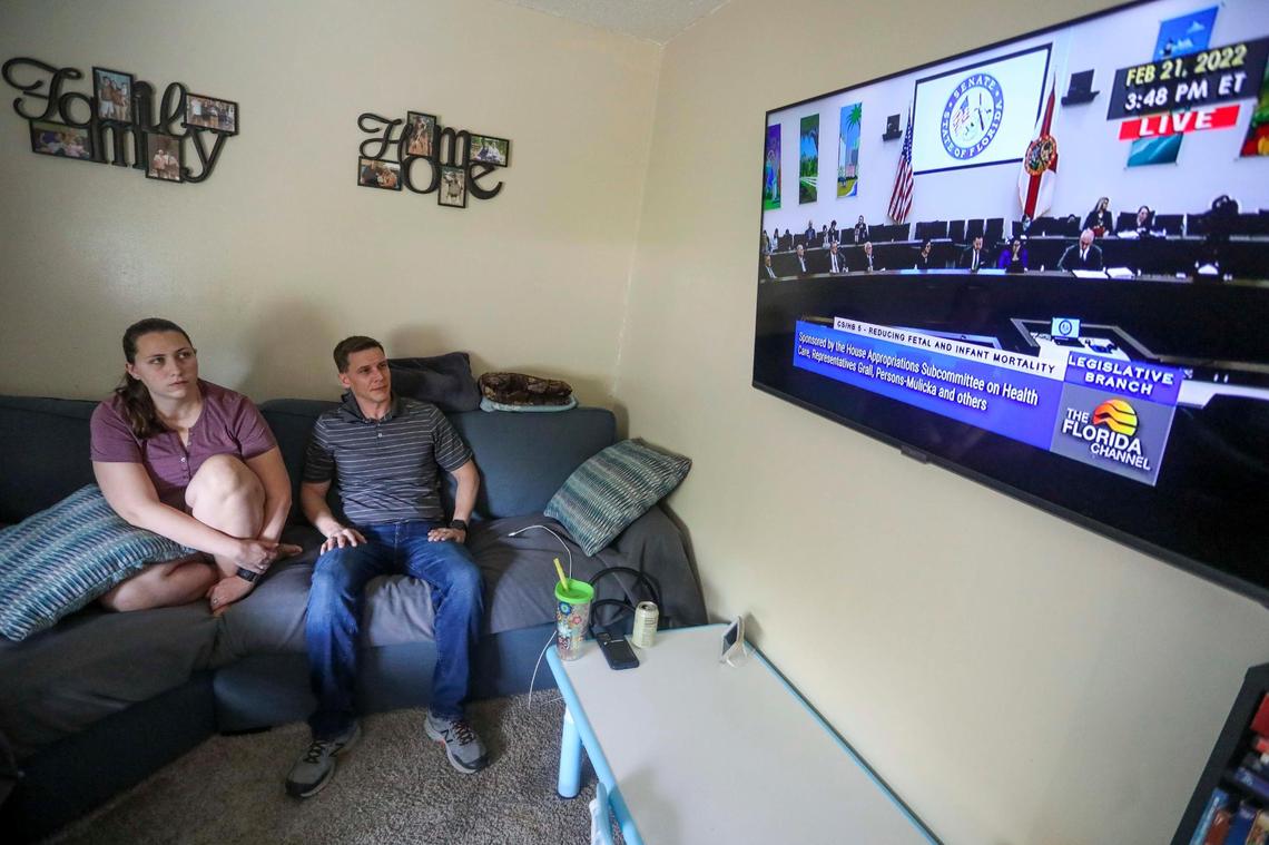 Danielle Tallafuss, 35, and her husband Jason Tallafuss, 42, watch as Bill SB 146 passes the Senate Appropriations Committee vote in the living room of their Oveido home on Monday, Feb. 21, 2022. The bill would ban most abortions in the state after 15 weeks of pregnancy. Danielle and her husband decided to terminate her first pregnancy at 22 weeks upon learning that Nathaniel would have been born with hypoplastic left-heart syndrome, an underdevelopment of the left side of the heart, to protect their child from the toll his condition would take on his life.