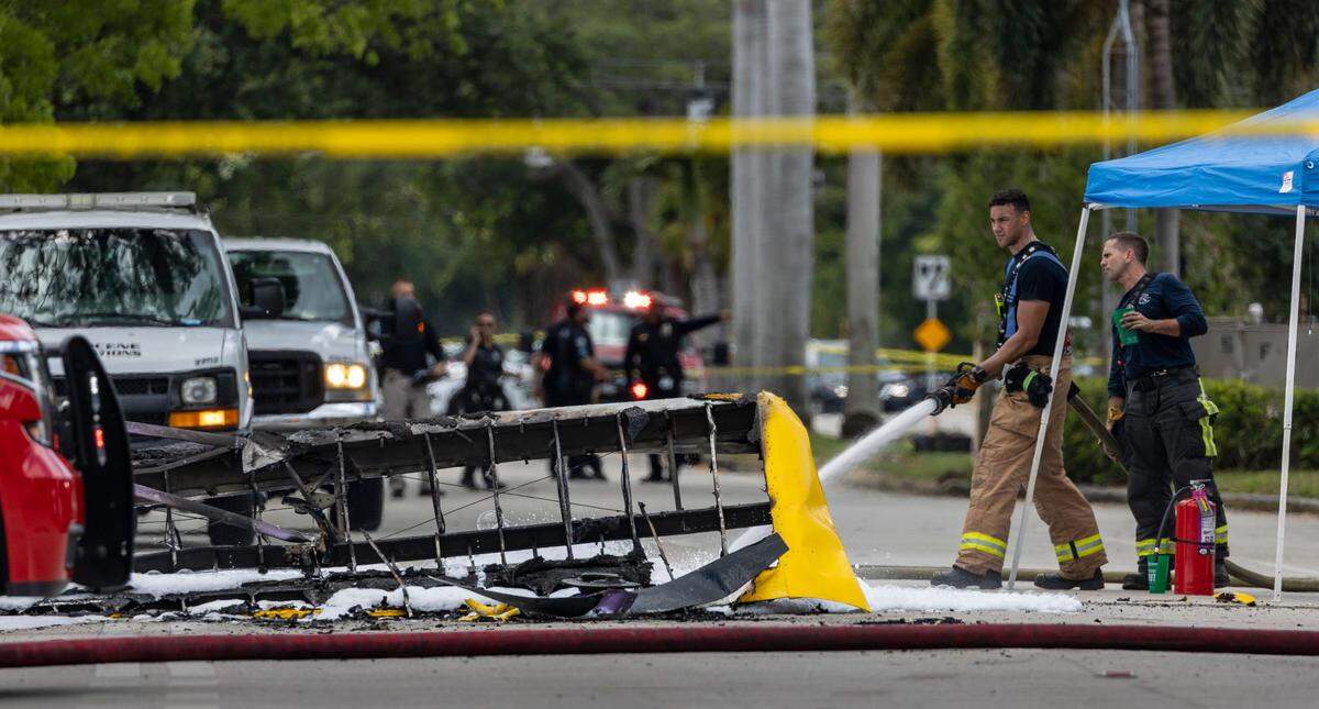 A fireman sprays foam on the wreckage of a small banner plane that crashed at 450 North Park Road in Hollywood, Florida, on Wednesday, May 17, 2023.