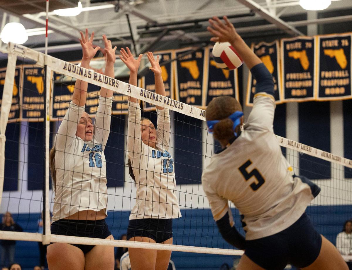 Lourdes Academy’s Amanda Travieso (16) and Alexa Espin (13) jump up for a black against St. Thomas Aquinas’ Sydney Vancott (5) during the regional volleyball championship on Wednesday, Nov. 1, 2023, at St. Thomas Aquinas School in Fort Lauderdale.