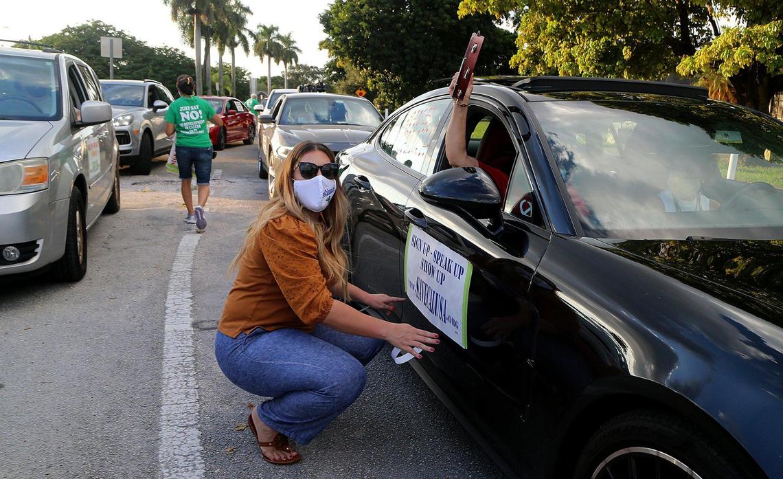 Vanessa Vazquez posts a poster on Caridad Vazquez’s car as residents of the Calusa neighborhood in Kendall began a rally and drive-through demonstration last year to “Save Calusa,” as part of a campaign to prevent redevelopment of the golf course land into a 550-house subdivision.