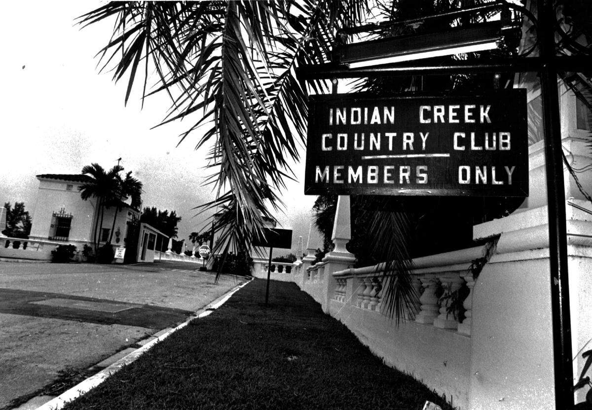 A sign at the entrance to the Indian Creek Country Club with a guard house in background in 1985.