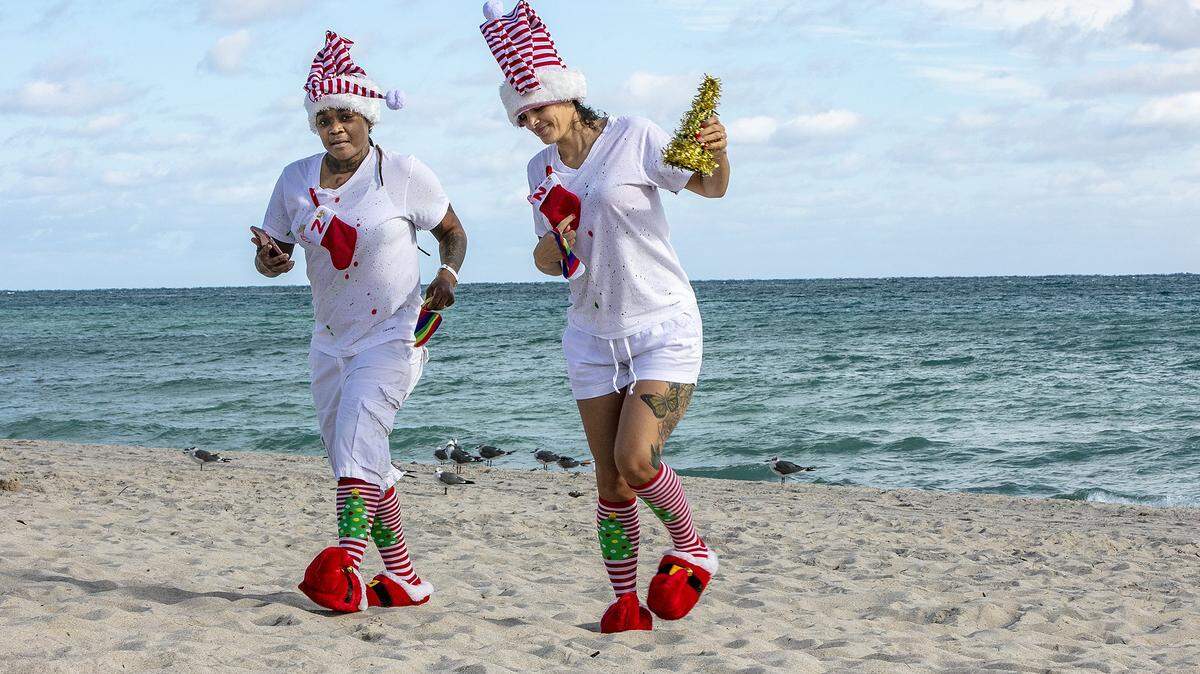 In this file photo from Dec. 25, 2020, Azizi and Nicolle Anthony hit North Beach on a chilly 56-degree Christmas morning that year. For Christmas 2025 expect warmer weather, around 70 in the morning and near 80 in the afternoon.