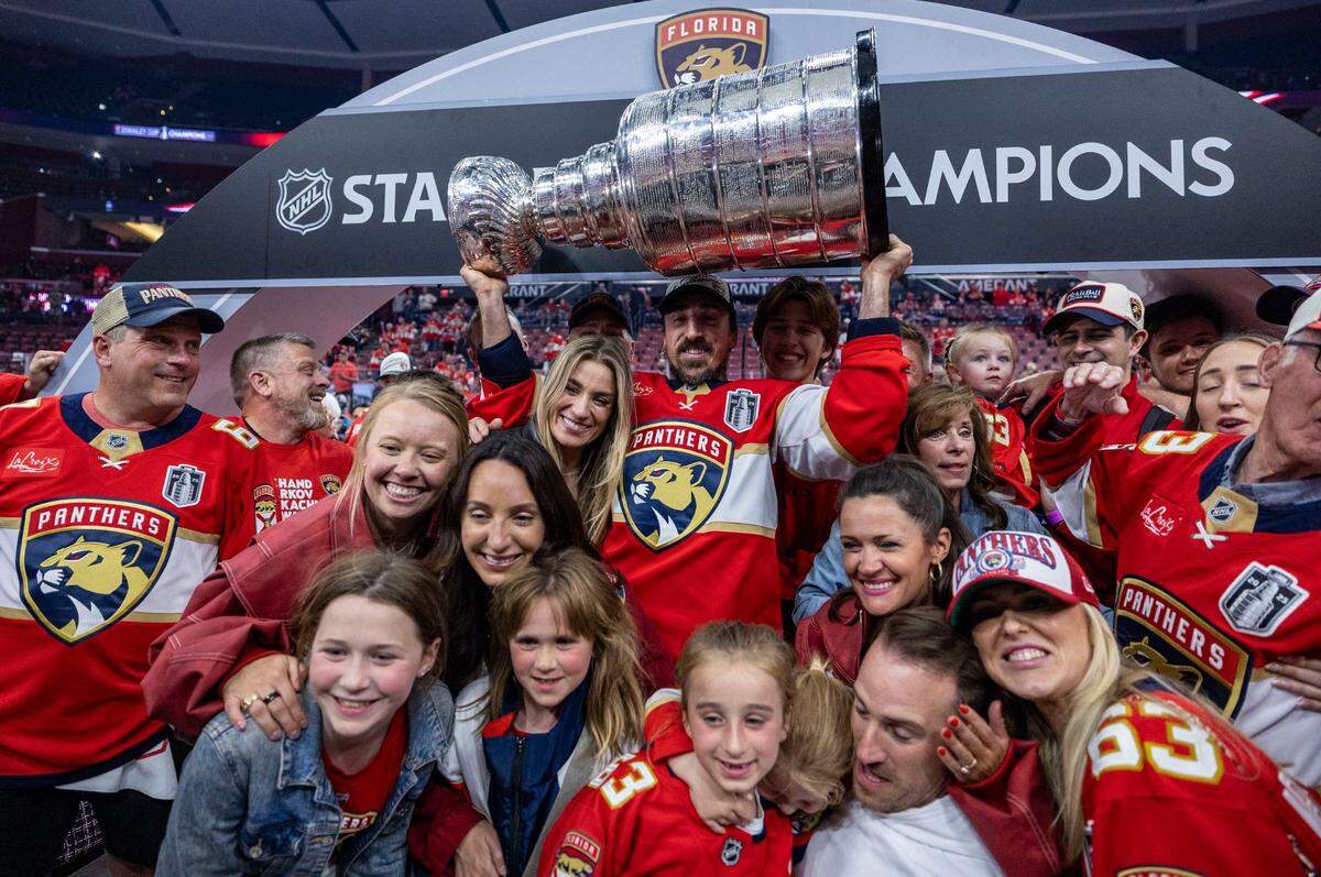Florida Panthers center Brad Marchand (63) lifts the Stanley Cup as he poses with members of his family after the Panthers defeated the Edmonton Oilers in Game 6 