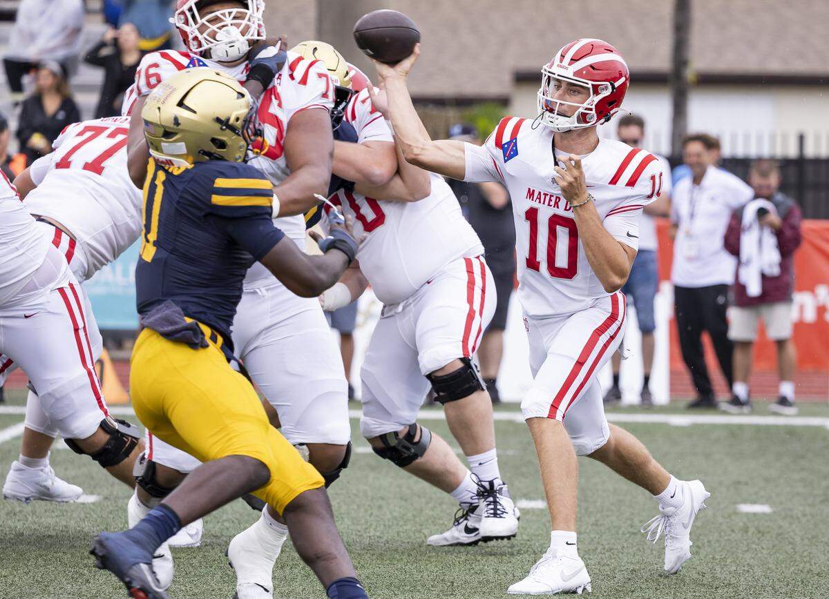 Mater Dei Monarchs quarterback Ryan Hopkins (10) throws the ball as St. Thomas Aquinas Raiders defensive lineman Daniel Norman (11) tries to defend in the first half of their football game at St.Thomas Aquinas High School on Saturday, Aug. 23, 2025, in Fort Lauderdale, Fla.