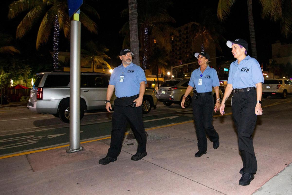 Civilian Volunteer Patrol members walk along Washington Avenue after a press conference introducing the new initiative outside Miami Beach Police Department headquarters on Monday, Dec. 13, 2021. The CVP uses trained volunteers to deter crime and report quality of life issues.