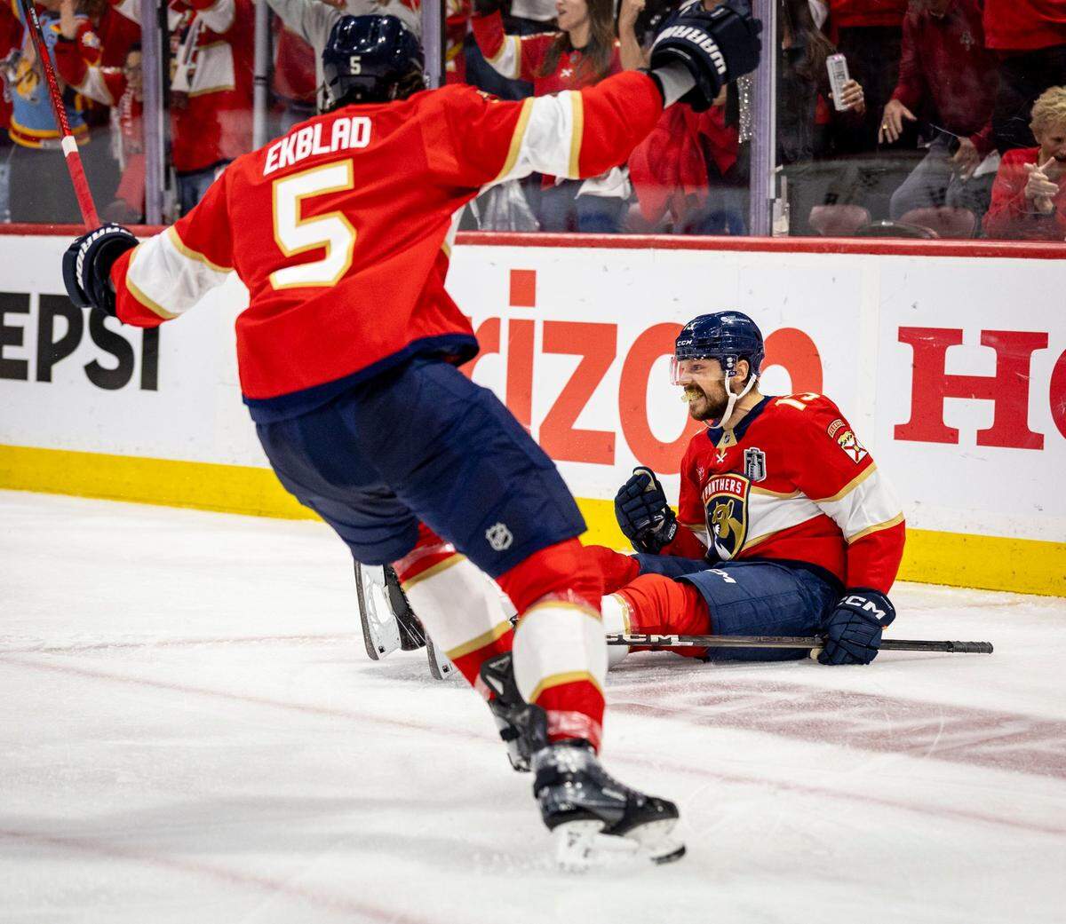 Florida Panthers center Sam Reinhart (13), right, celebrates on the ice after scoring the first goal of the game during the first period of Game 6 in the NHL Stanley Cup Final series at Amerant Bank Arena
