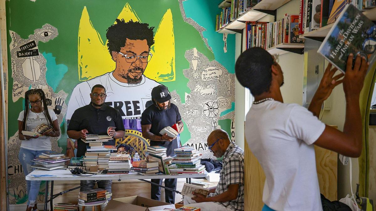 Sherina Jones, Isaiah Thomas, Phillip Agnew, Barney Agnew and Cameron Agnew (l. to r.) sort and place books on the shelves while preparing for the opening of Roots Bookstore and Marketplace, the brainchild of the late Danny Agnew. The shop is set to open on Juneteenth.
