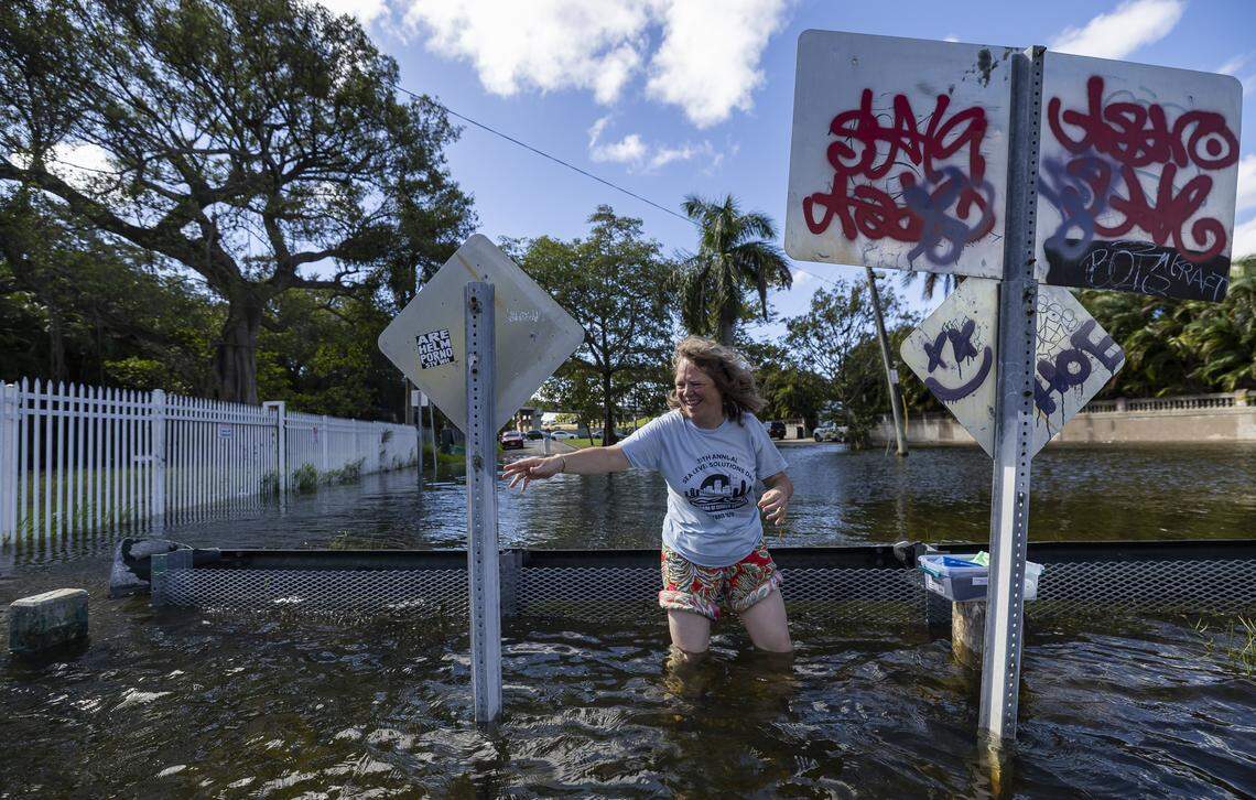 Monique Bennema, 59, economic policy officer Consulate General of the Kingdom of the Netherlands, wades into the water as she prepares to measure king tide during Florida International University's Sea Level Solutions Day at Grove Park on Wednesday, Oct, 8, 2025, in Miami, Fla.