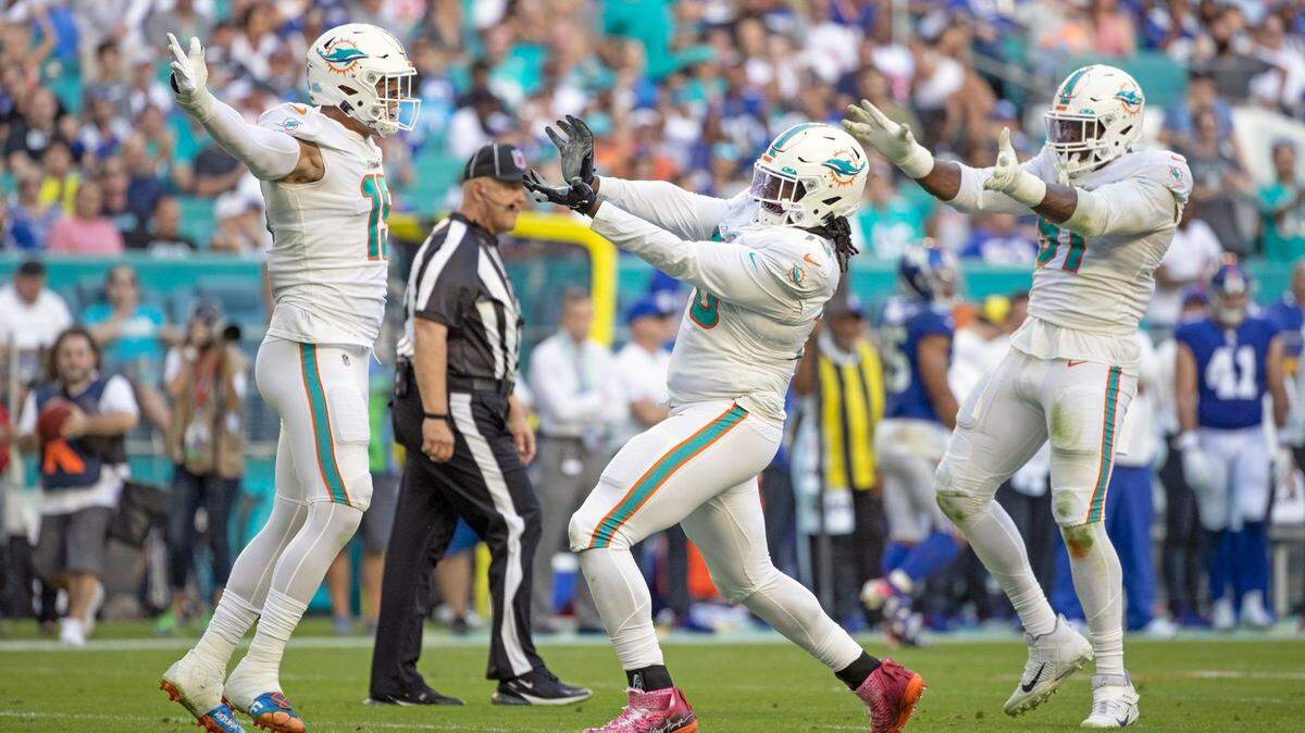 Miami Dolphins outside linebacker Jaelan Phillips (15), nose tackle Adam Butler (70) and defensive end Emmanuel Ogbah (91) react after Butler sacks New York Giants quarterback Mike Glennon (2) in the fourth quarter at Hard Rock Stadium in Miami Gardens on Sunday, December 05, 2021. ( Al Diaz Photo / Miami Herald )