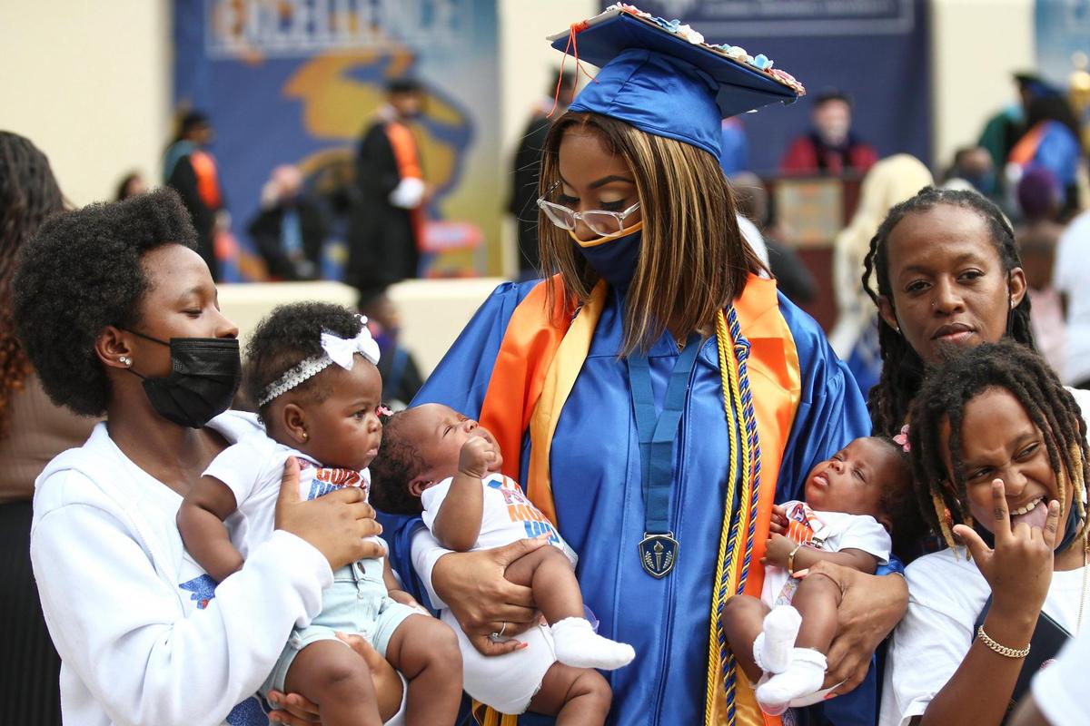 Queen Aguila, who graduated from Florida Memorial University in 2020 but did not have a commencement ceremony due to the COVID-19 pandemic, holds her two-month-old twin babies, Kairi and Karasi, after attending her graduation ceremony with her family at the FMU campus in Miami Gardens, Florida on Saturday, May 8, 2021.