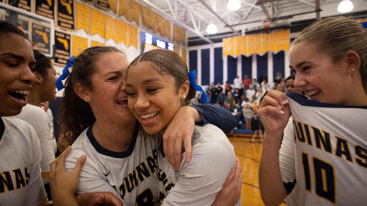 Raiders Riley Gulla (8) hugs Sydney Vancott (5) while Zoe Taylor (10) smiles while they celebrate a win in the regional volleyball championship against Lourdes Academy on Wednesday, Nov. 1, 2023, at St. Thomas Aquinas School in Fort Lauderdale.