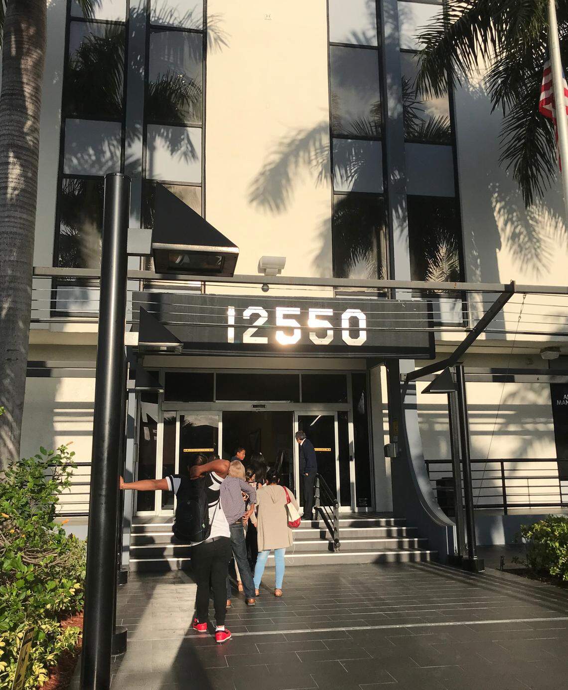 Immigrants wearing ankle monitors enter building on Biscayne Boulevard as part of regular check-in requirements. 