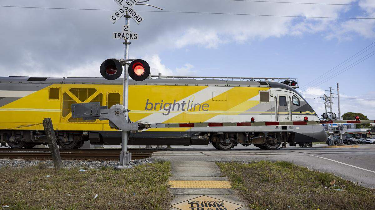 A Brightline train crosses through Northwest 20th Street near North Dixie Highway on Thursday, April 10, 2025, in Boca Raton, Florida.