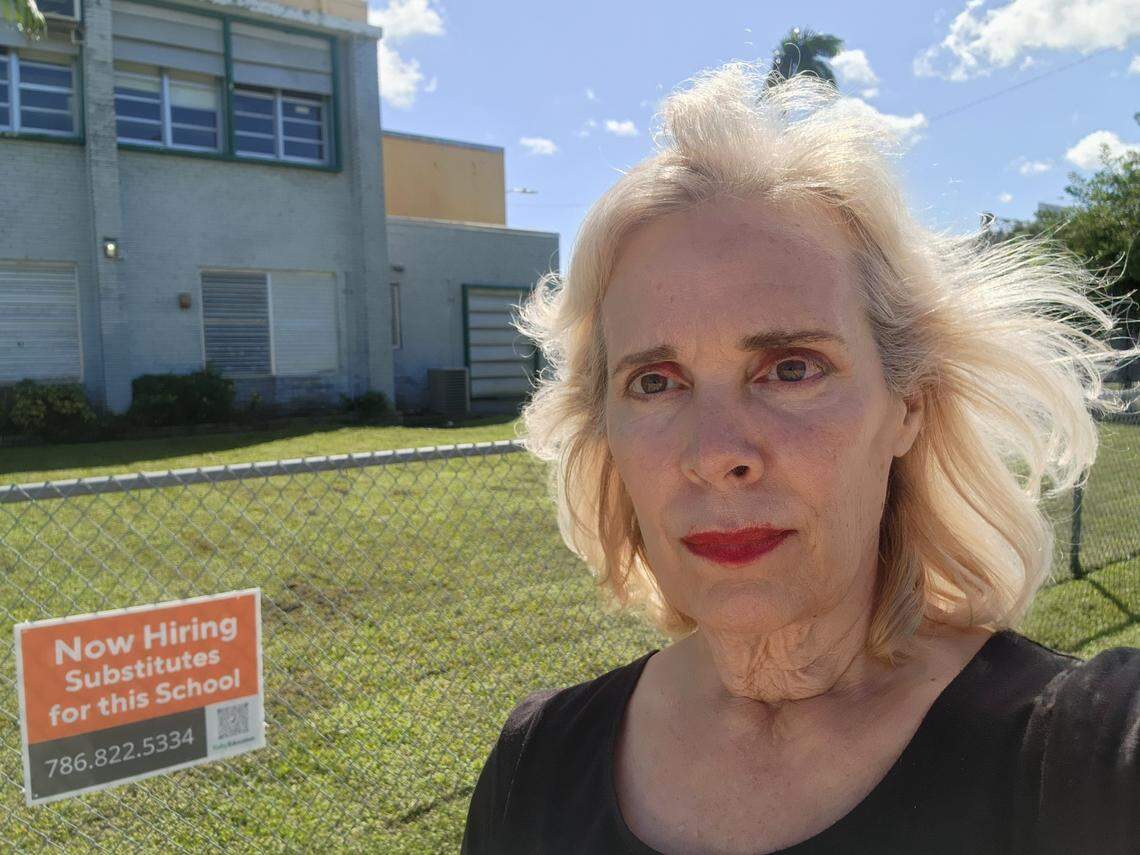 Miami-Dade Schools teacher Marta Zayas poses next to a Kelly Education sign outside of Biscayne Gardens Elementary School. The school district recently signed a contract with Kelly Education to manage its substitute teachers and lowered the requirements. Now, anyone who meets the age requirements and has a traditional high school diploma or has passed the GED exam is eligible to apply to become a substitute teacher.