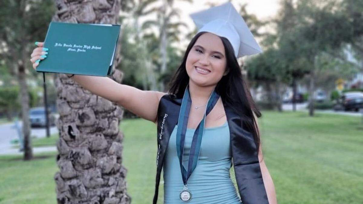 Angela Pacalagua, wearing a graduation cap and a stole, holds a Felix Varela Senior High School diploma.