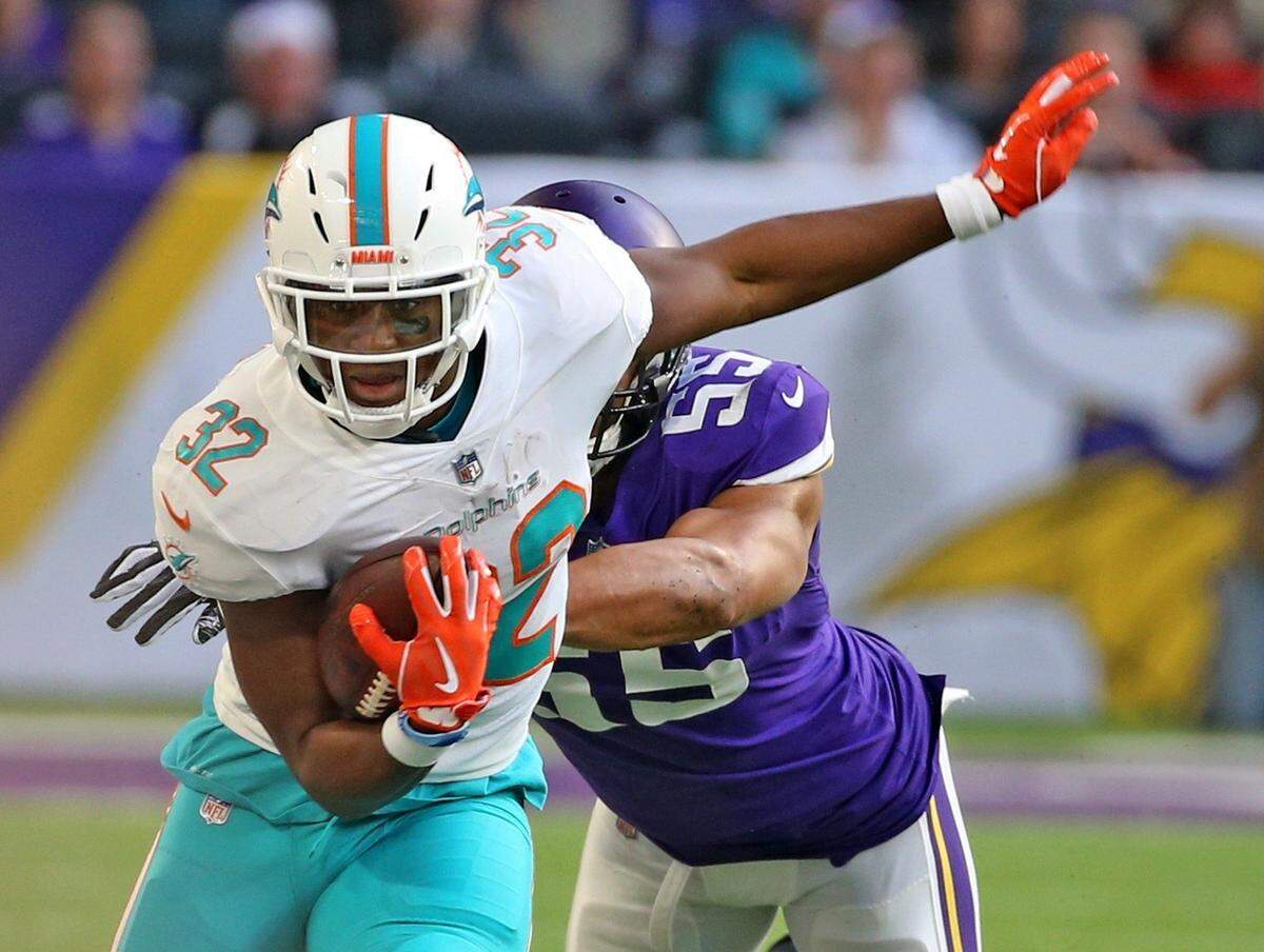 Miami Dolphins Kenyan Drake (32) is pushed out of bounds against the Minnesota Vikings in Minneapolis, Sunday, Dec., 16, 2018.
