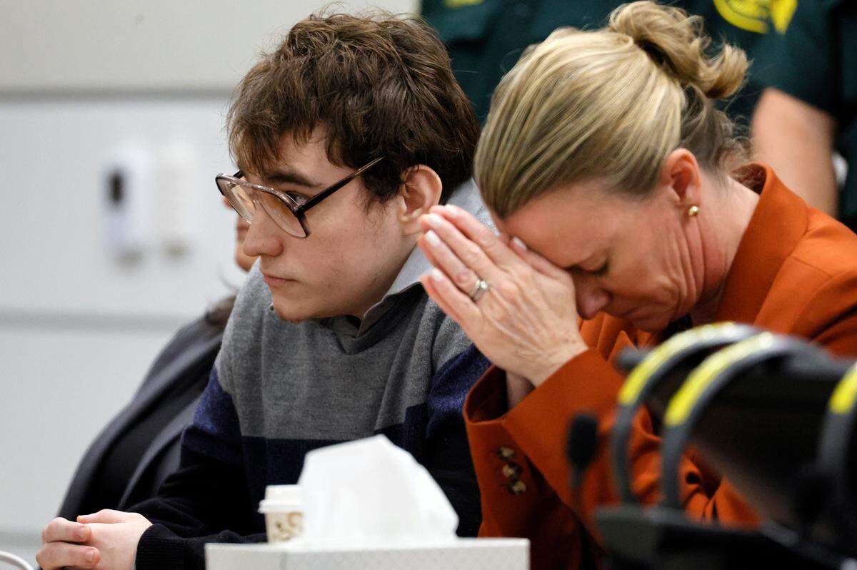 Assistant Public Defender Melisa McNeill, seated with Marjory Stoneman Douglas High School shooter Nikolas Cruz, touches her hands to her head as the last of the 17 verdicts were read in the penalty phase of Cruz’s trial at the Broward County Courthouse in Fort Lauderdale on Thursday, Oct. 13, 2022. Cruz, who pleaded guilty to 17 counts of premeditated murder in the 2018 shootings, is the most lethal mass shooter to stand trial in the U.S. He was previously sentenced to 17 consecutive life sentences without the possibility of parole for 17 additional counts of attempted murder for the students he injured that day.