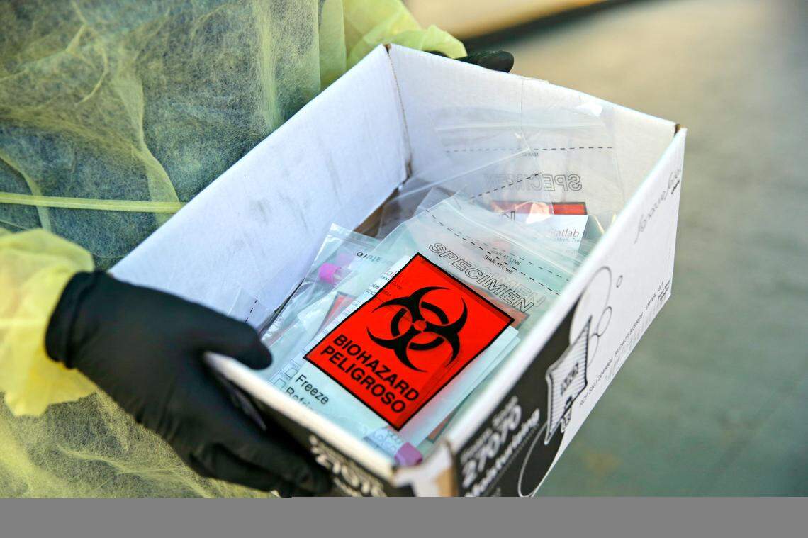A Florida Department of Health worker holds a box with a swab tests from residents of a Miami long-term care facility.
