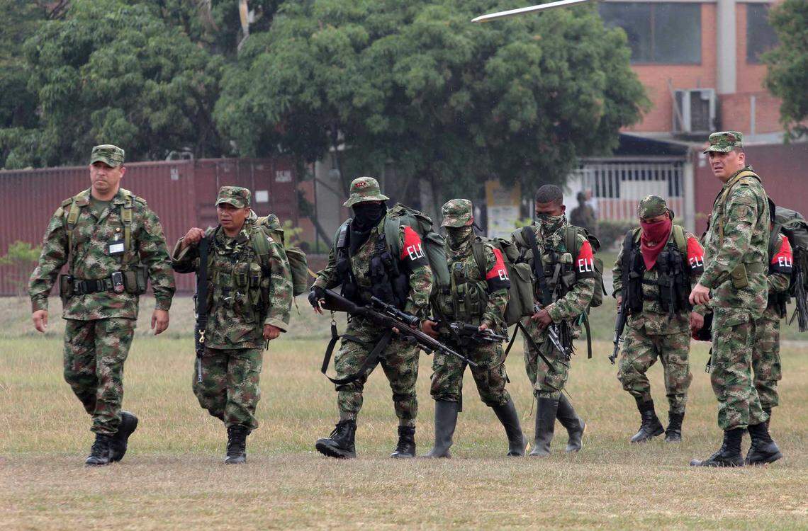 Soldiers, left and right, escort rebels of the National Liberation Army, ELN, who gave themselves up upon their arrival to a military base in Cali, Colombia. Groups such as ELN have become important middlemen in facilitating the flow of drugs through Venezuela en route to the United States.