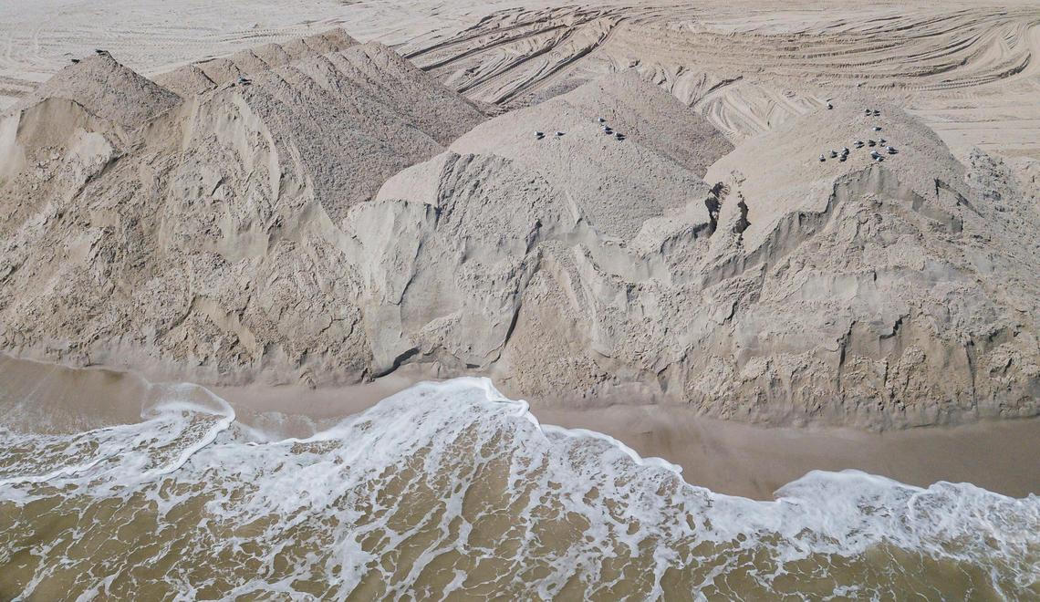 Mounds of sand sit on Miami Beach near Indian Beach Park as crews working for the U.S. Army Corps of Engineers undertake a beach renourishment project on Oct. 12, 2022.
