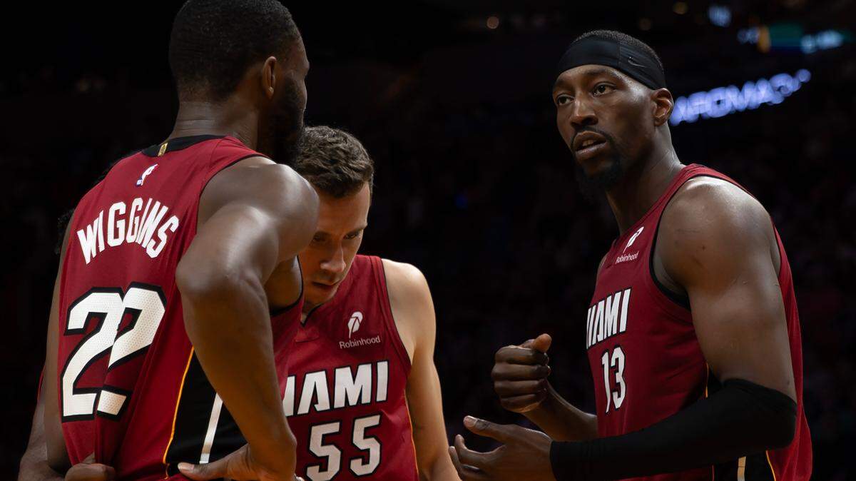 El centro del Heat, Bam Adebayo (der.), se reúne con sus compañeros Andrew Wiggins (izq.) y Duncan Robinson, durante el partido de la NBA contra los Celtics de Boston, celebrado el 14 de marzo de 2025 en Miami.