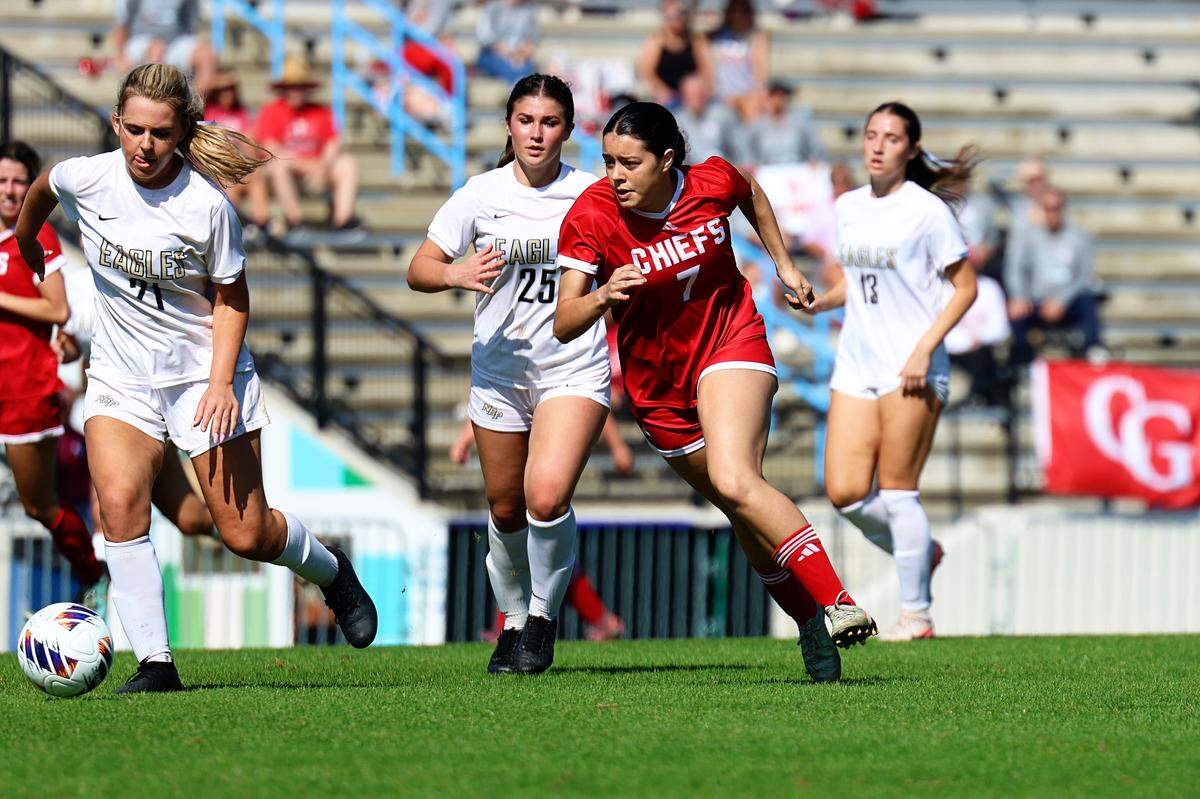 Cardinal Gibbons’ Emma Heim (red jersey) races North Broward Prep’s Sophie Souza (left) to the ball during Thursday’s Class 3A state semifinal at Lake Myrtle Sports Complex in Auburndale, Fla.