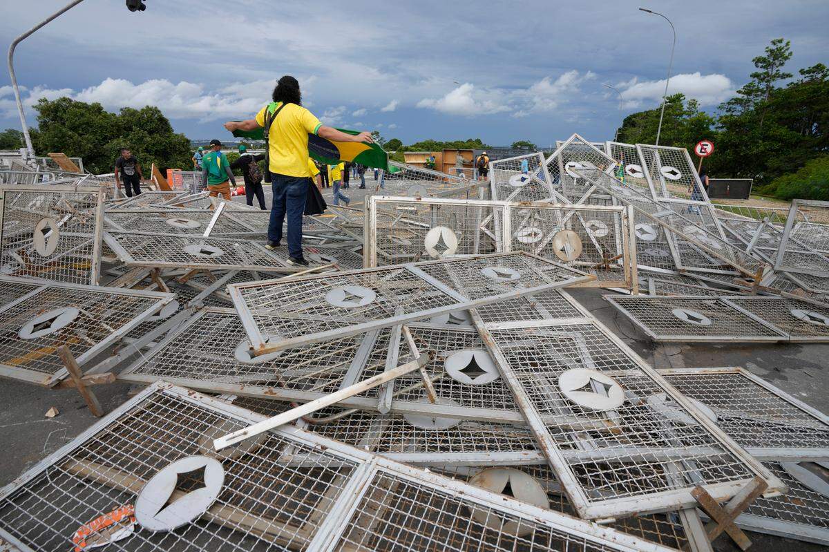 Protesters, supporters of Brazil’s former President Jair Bolsonaro, stand over barricades as they storm the Planalto Palace in Brasilia, Brazil.