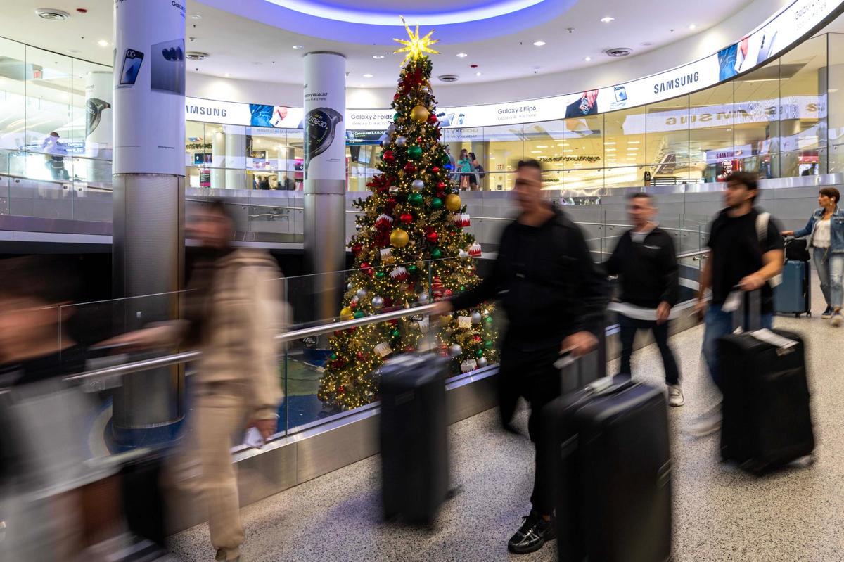 Travelers walk past a Christmas tree while leaving U.S. Customs at Miami International Airport on Thursday, Nov. 21, 2024, in Miami, Fla.