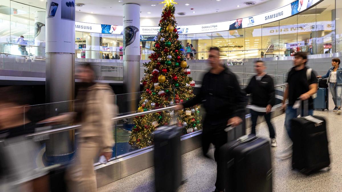 Travelers walk past a Christmas tree while leaving U.S. Customs at Miami International Airport on Thursday, Nov. 21, 2024, in Miami, Fla.