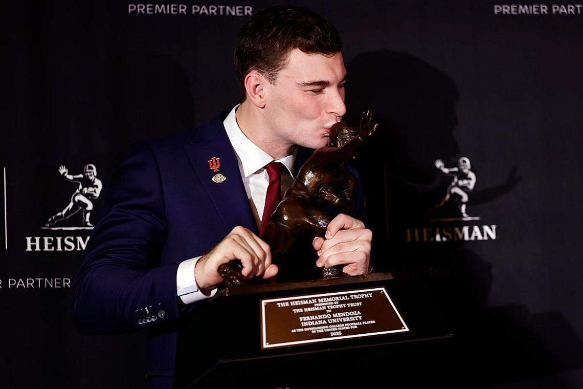 NEW YORK, NEW YORK - DECEMBER 13: 2025 Heisman Trophy winner quarterback Fernando Mendoza of the Indiana Hoosiers kisses The Heisman Memorial Trophy during a news conference at the Marriott Marquis Hotel on December 13, 2025 in New York City. (Photo by Adam Hunger/Getty Images)