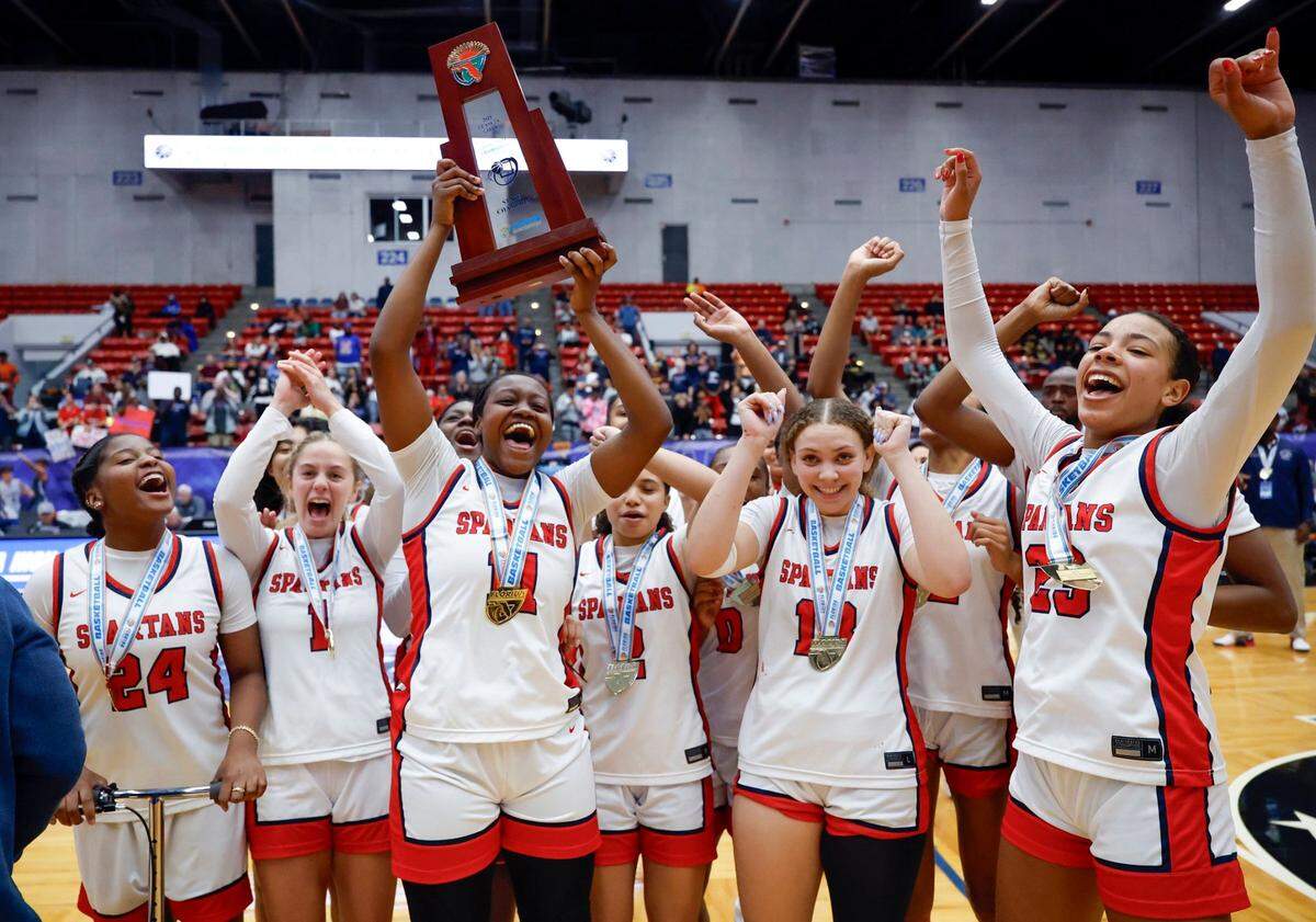 Miami Country Day’s Jada Johnson (11) lifts the state championship trophy after defeating Providence School for the FHSAA Class 2A Girls High School Basketball State Championship.