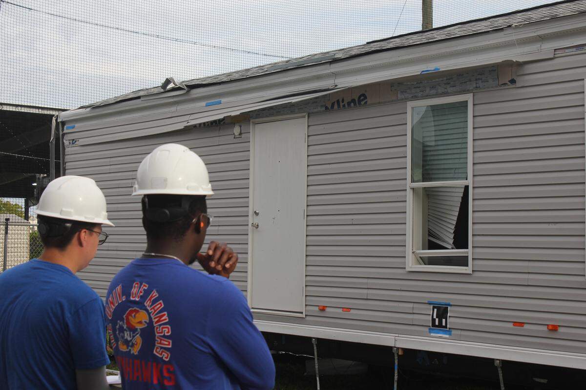 Two researchers assess the results of their first test on a manufactured house against hurricane-force winds at Florida International University’s School of Engineering on May 13, 2026.
