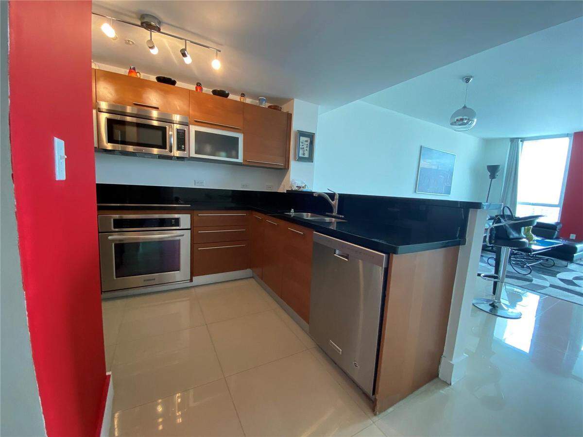 Pictured above: The apartment’s U-shaped kitchen has stainless steel appliances and looks over the living room.