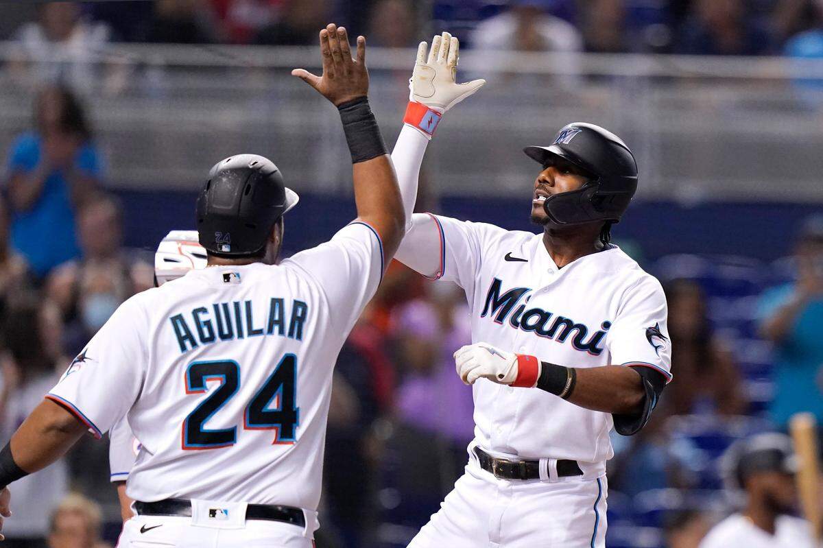 Miami Marlins’ Lewis Brinson, right, is met by Jesus Aguilar (24) after hitting a grand slam off New York Mets starting pitcher Tylor Megill during the first inning of a baseball game, Monday, Aug. 2, 2021, in Miami. (AP Photo/Lynne Sladky)