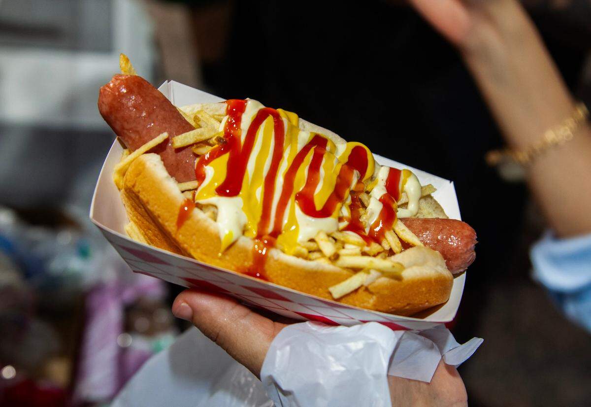 A customer buys a hot dog from Chill N’ Burger during the Fourth of July Bayfront Park Celebration at Bayfront Park on Tuesday, July 4, 2023 in Miami, Fla.