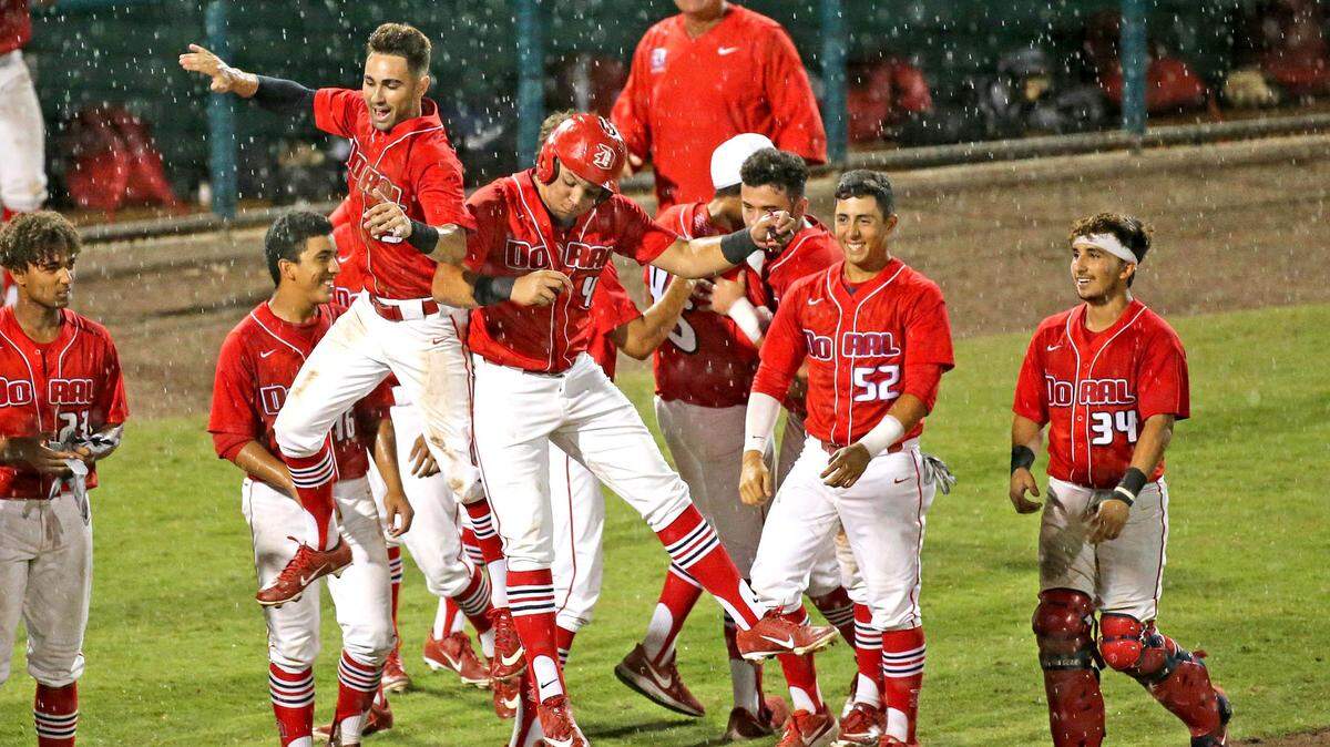 Doral Academy Matthews Corpas (13) and Abner Benitez (4) celebrate in the rain as they defeat Leto HS in the FHSAA Semi-Final Class 7A Division at CenturyLink Sports Complex - Hammond Stadium in Fort Myers, Florida, Friday, May, 31, 2019.