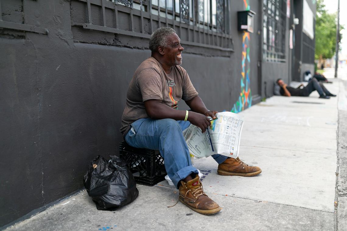 Harold Norman, 59, reads the newspaper near the Miami Rescue Mission Clinic.