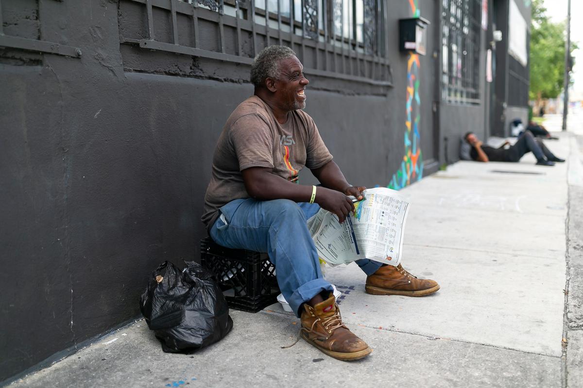 Harold Norman, 59, reads the newspaper near the Miami Rescue Mission Clinic.