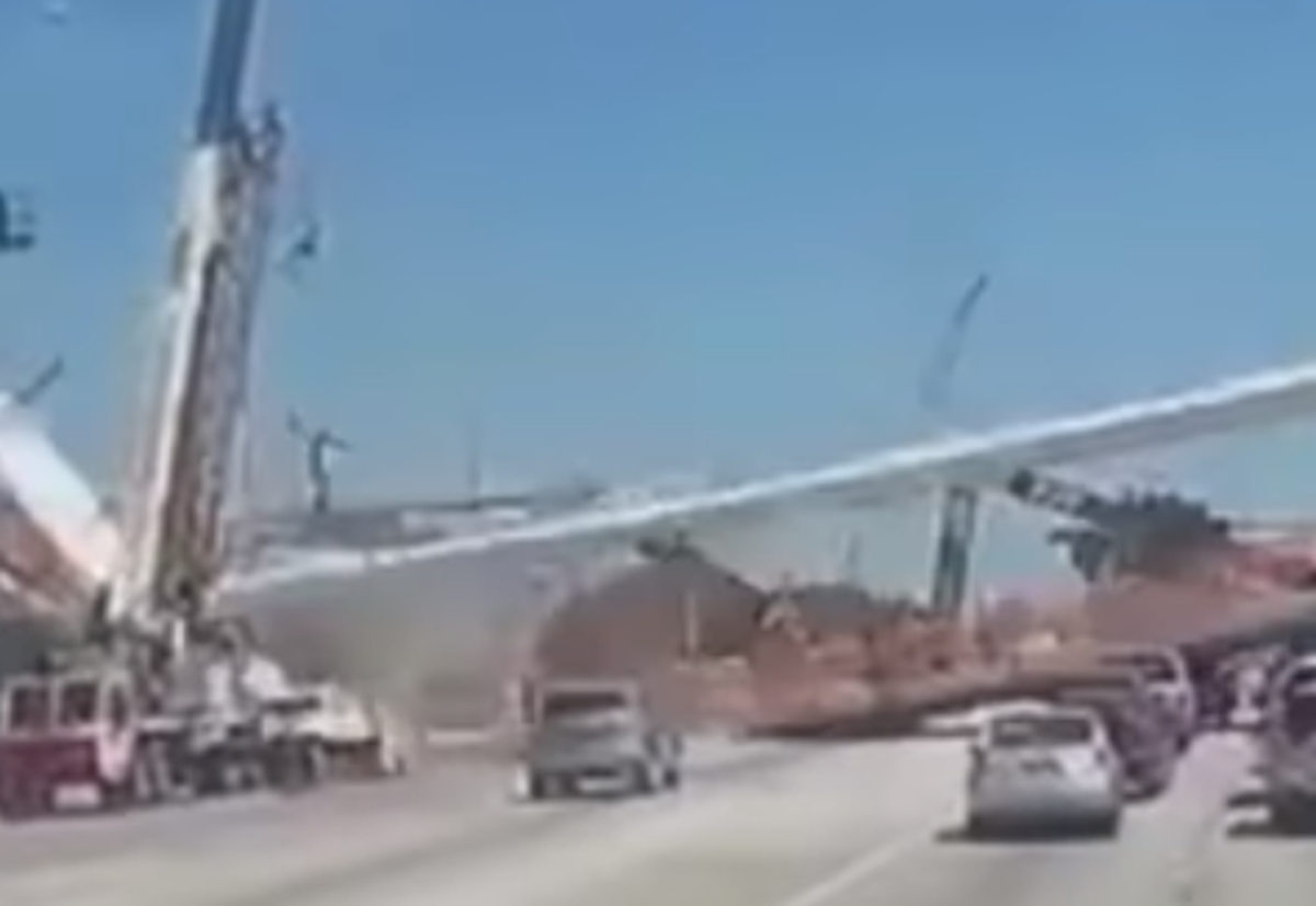 This image shows a worker, visible near the crane on the left, falling after the Florida International University bridge over Southwest Eighth Street (Tamiami Trail) gave way on March 15, 2018. Five motorists and one worker died, and five other workers were injured.
