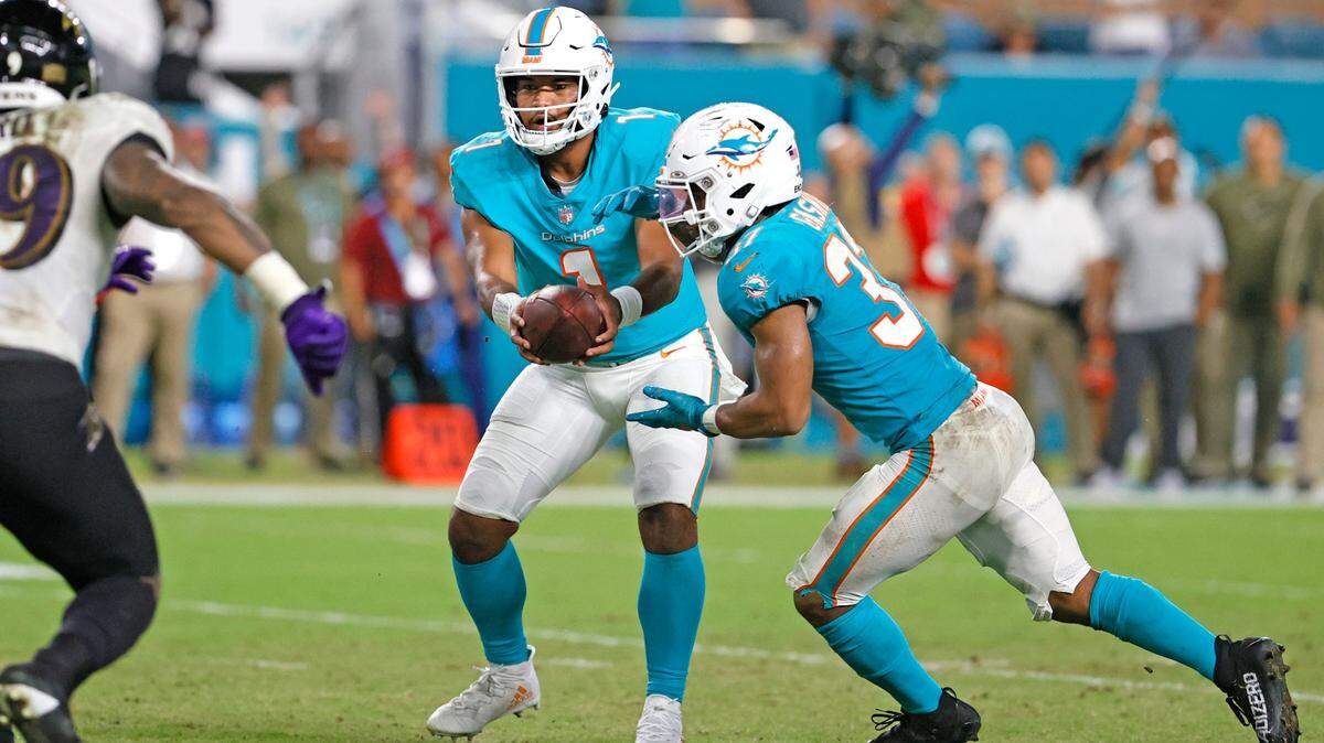 Miami Dolphins quarterback Tua Tagovailoa (1) hand off to running back Myles Gaskin (37) during the fourth quarter of an NFL football game against the Baltimore Ravens at Hard Rock Stadium on Thursday, November 11, 2021 in Miami Gardens, Florida.