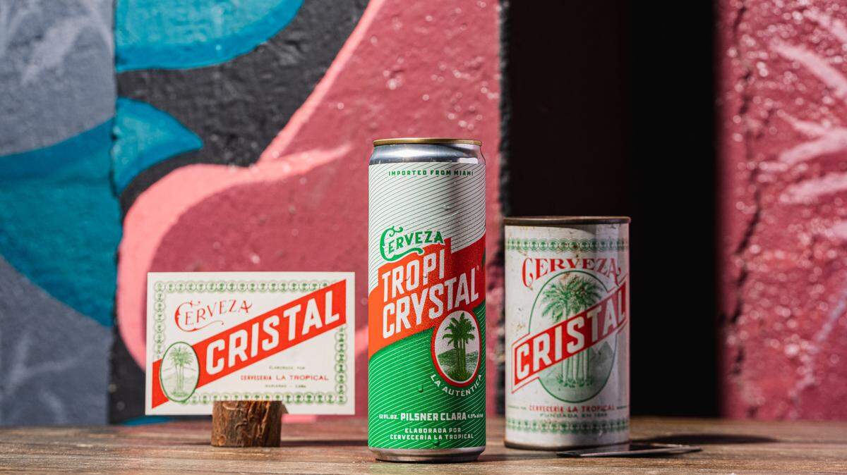 The new, green Tropi Crystal can, at left, features the words “ “La Auténtica.” Next to it is the original Cristal can, which was first brewed in Cuba in 1928.