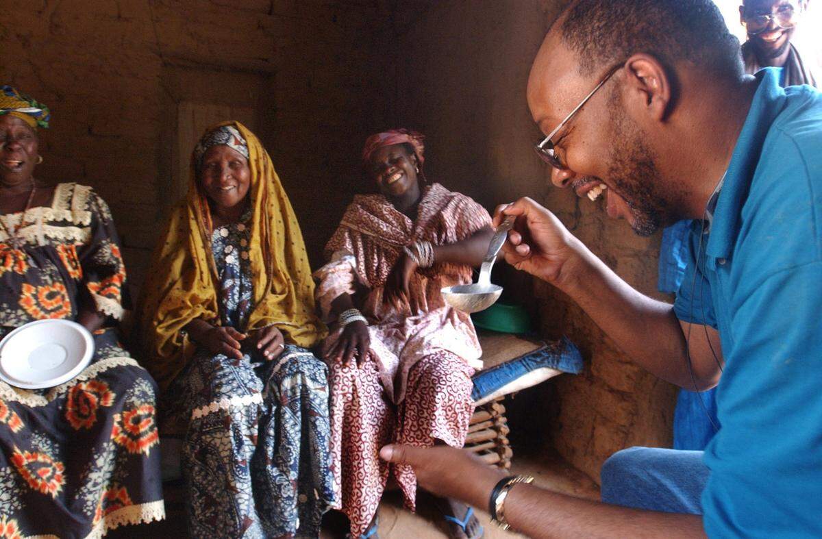 In this file photo from July 15, 2004, Miami Herald columnist Leonard Pitts Jr. tries a millet drink while visiting Tera Village. The drink is called donou, comprised of millet and milk. Pitts didn’t like the taste. Pitts grimaced, “It tastes like warm yogurt.” Millet is a staple Songhi crop and the millet drink mixture is drank daily by Songhi people. Through DNA analysis at www.africanancestry.com, Pitts had his heritage traced to the Songhi people of Niger and the Mende people of Sierra Leone. The story encompassed his experience as an African American going back to Africa.