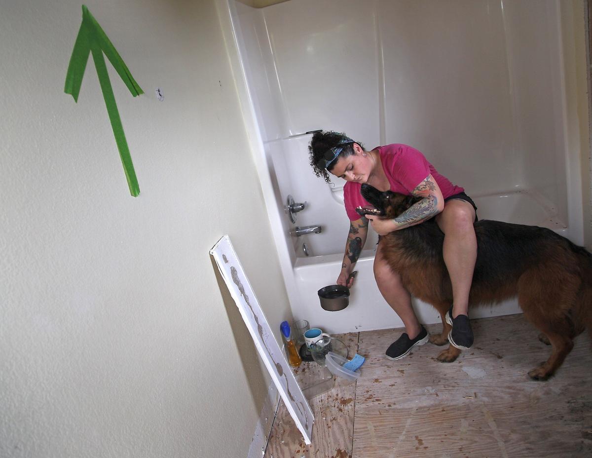 On Thursday, August 30, 2018 Key Largo resident Melinda Goodro and her wife, are having a tough time getting paid by Citizens Insurance after damages from Hurricane Irma nearly a year ago. Goodro is photographed inside her damaged third floor bathroom with her dog “Qynn.” She is still living in her RV a year later. Her three-story home suffered heavy roof and water damage and repairs can not be made until insurance claim has been resolved.