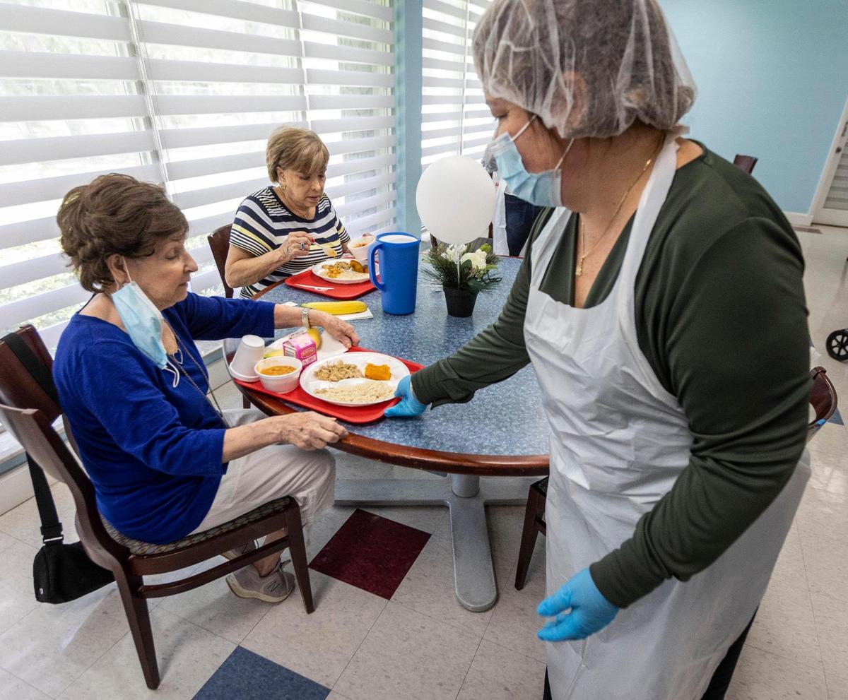 Dining room coordinator Barbara Hernandez, right, serves meals to residents of Carroll Manor Senior Center on May 25, 2021. This is the first week of senior centers reopening their cafeterias. Many senior centers have not opened, but the Little Havana Activities and Nutrition Centers has reopened four, including Carroll Manor, and plans to open four more by June 14.
