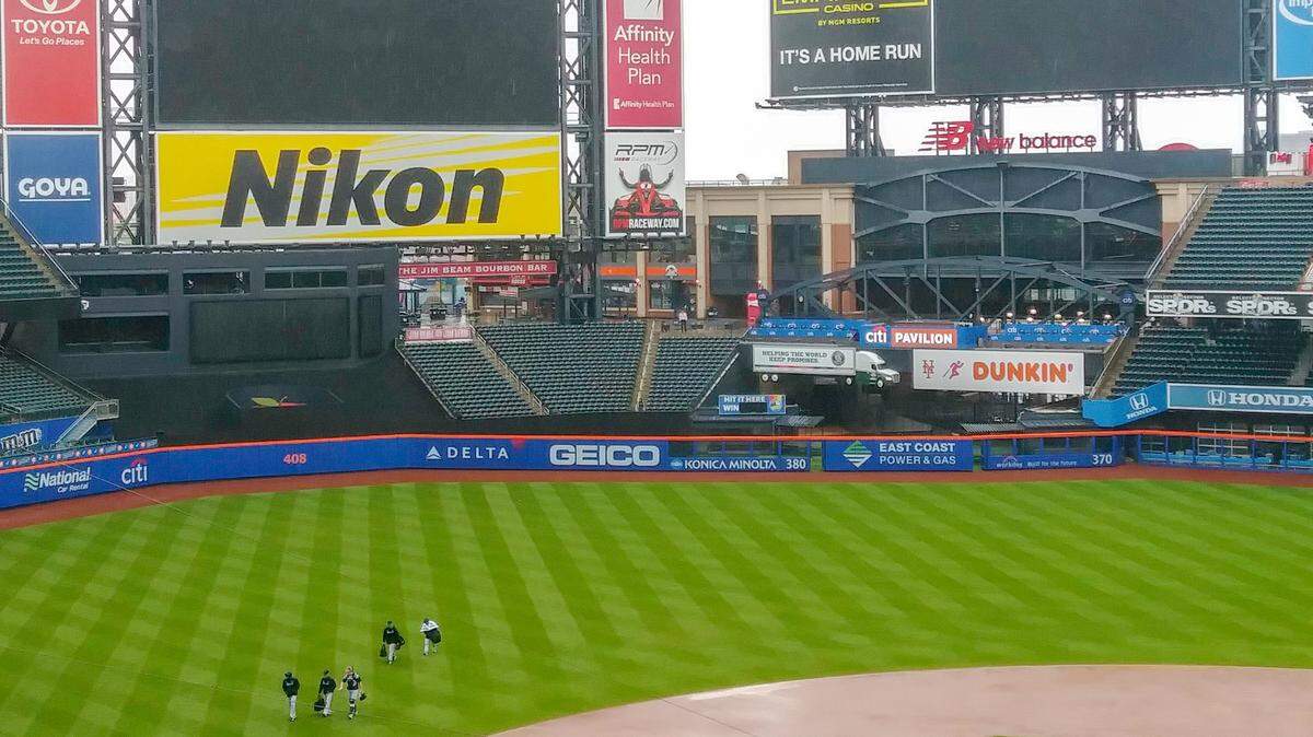 Miami Marlins pitchers and catchers walk through the Citi Field outfield in the rain back to their clubhouse following a bullpen session on Sunday, May 12, 2019. The Marlins’ series finale against the New York Mets was postponed due to inclement weather.