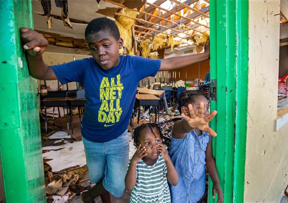 Wajeid Romin, 10, with his sisters Wanita Romin, 2, and Wyomi Romin, 4, at right, took shelter with family at Central Abaco Primary school during Hurricane Dorian at Marsh Harbour on Abaco Island on Saturday, September 7, 2019. The family is still at the temporary shelter.