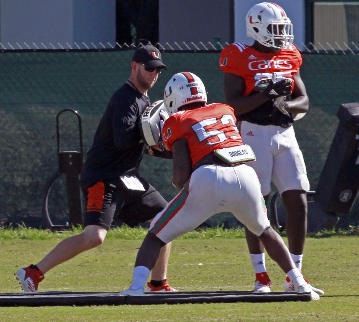 UM current defensive assistant coach, Jonathan Patke, left, coaches at practice at the Hecht Athletic football field on Tuesday, December 18, 2018,