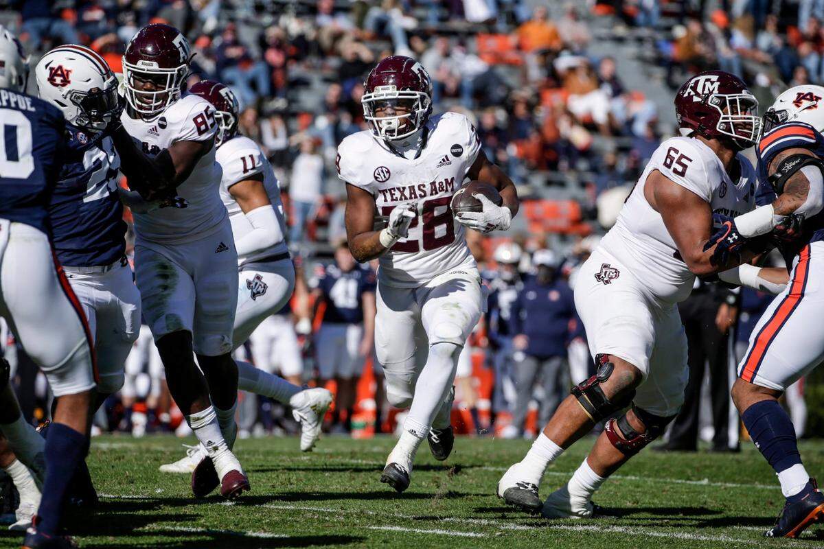 Texas A&M running back Isaiah Spiller (28) carries the ball during the first half of an NCAA college football game against Auburn on Saturday, Dec. 5, 2020, in Auburn, Ala. (AP Photo/Butch Dill)