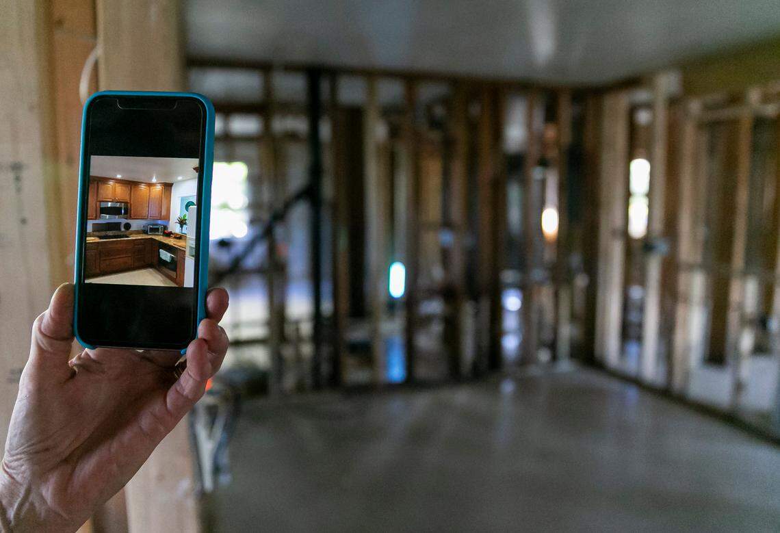 Jennifer, 65, shows a photo of her kitchen before Hurricane Ian destroyed it while giving a tour of her damaged home on Tuesday, Oct. 18, 2022, in Bonita Shores.